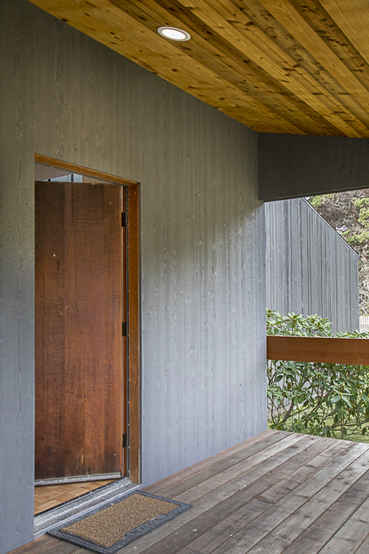 The front deck of the house with the front door slightly ajar.