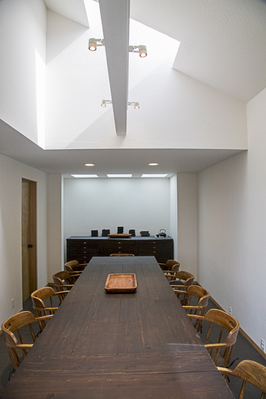 A conference room with ten chairs and two tables.