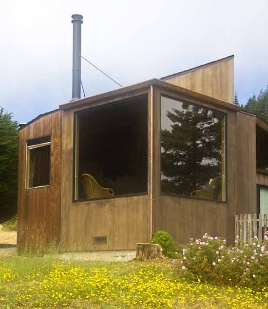 The exterior of the home showing two very large windows.