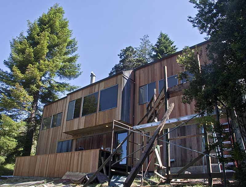 The exterior of the home show=ing the reconstruction of the deck in the foreground.